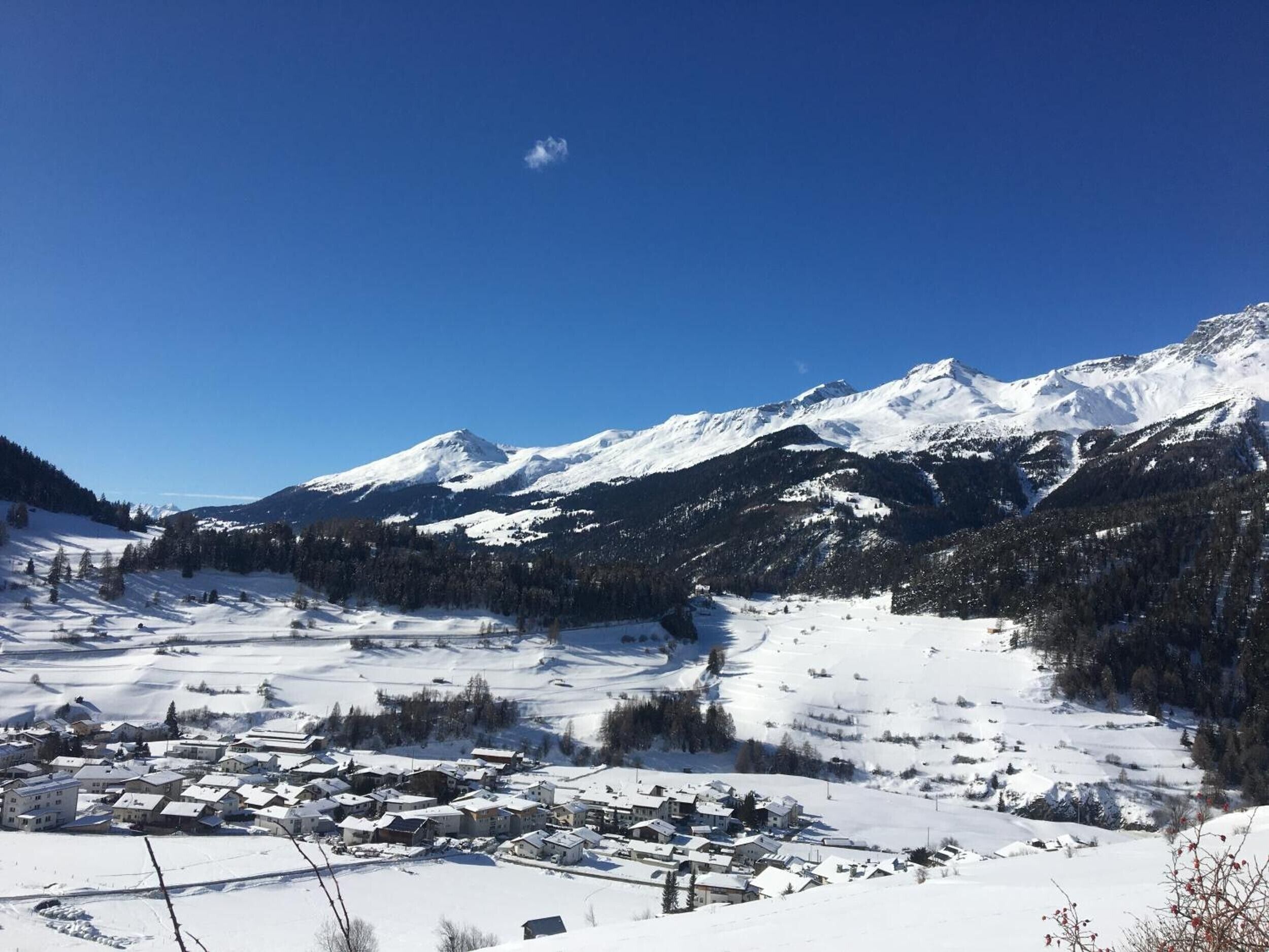 A snow-covered mountain landscape with a small town in the foreground.