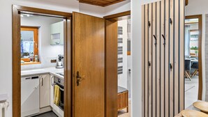A modern kitchen with wooden cabinets, a built-in oven, and a dining area with a wooden table and chairs. - Holiday Apartment 'Quiet Basement Apartment with Terrace' with Private Terrace, Garden, and Wi-Fi (Altenkunstadt)