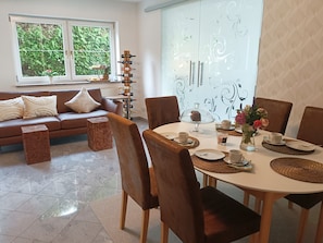 Un coin repas avec une table ronde, des chaises et un meuble à vin.