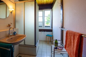 Une salle de bain équipée d’un lavabo, d’un miroir, d’une fenêtre et d’un porte-serviettes.