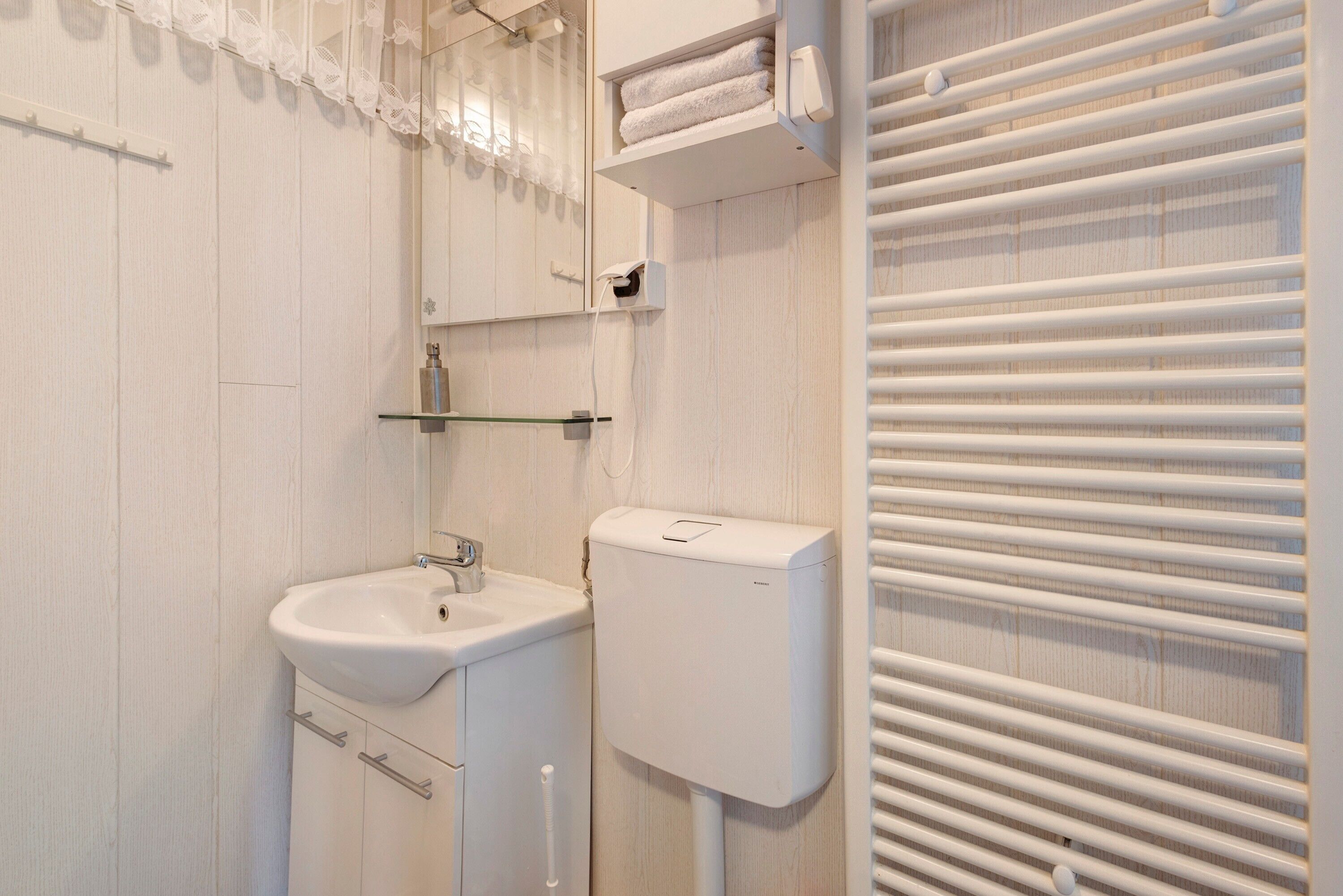 Ein Badezimmer mit Waschbecken, Toilette und Handtuchhalter.