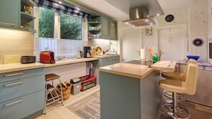 A modern kitchen with a central island, bar stools, and a view of the outdoors. - Holiday Apartment 'Ferienhaus Marchlewski' with Shared Garden and Wi-Fi (Brunsbüttel)