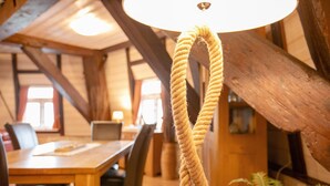A rope chandelier in a wooden interior with a dining table and chairs. - Apartment Inselblick with Island Views (Pellworm)