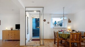 A dining area with a table, chairs, and a view of the outside. - Apartment Lilly with Private Terrace, Garden, and Wi-Fi (Hofgeismar)