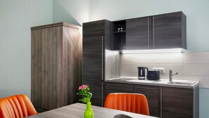 Une cuisine moderne avec des meubles de rangement sombres, un four encastré et un évier.