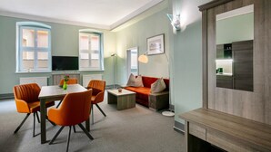 Un salon moderne comprenant un coin repas, un canapé, une table basse et un téléviseur.