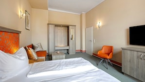 A hotel room with a bed, a desk, a chair, a wardrobe, and a television. - Apartment 'Ferienwohnung 3' with Shared Terrace and Wi-Fi (Luckau)
