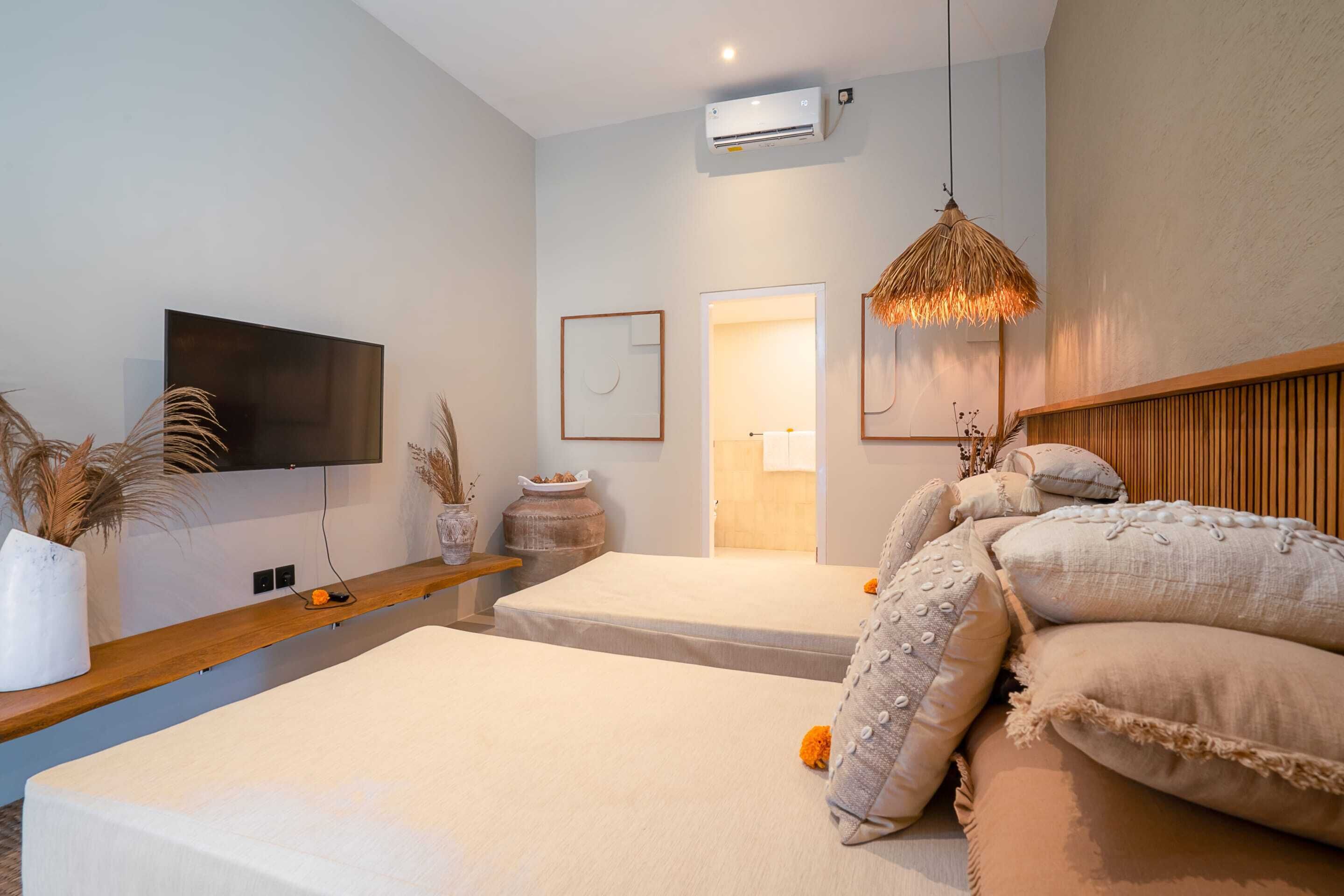 A modern bedroom with a flat-screen TV, a wooden headboard, and a large window.