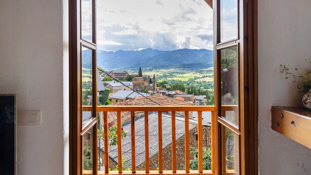 Un balcón con vistas a un pueblo y montañas.