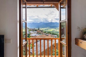 Un balcón con vistas a un pueblo y montañas.