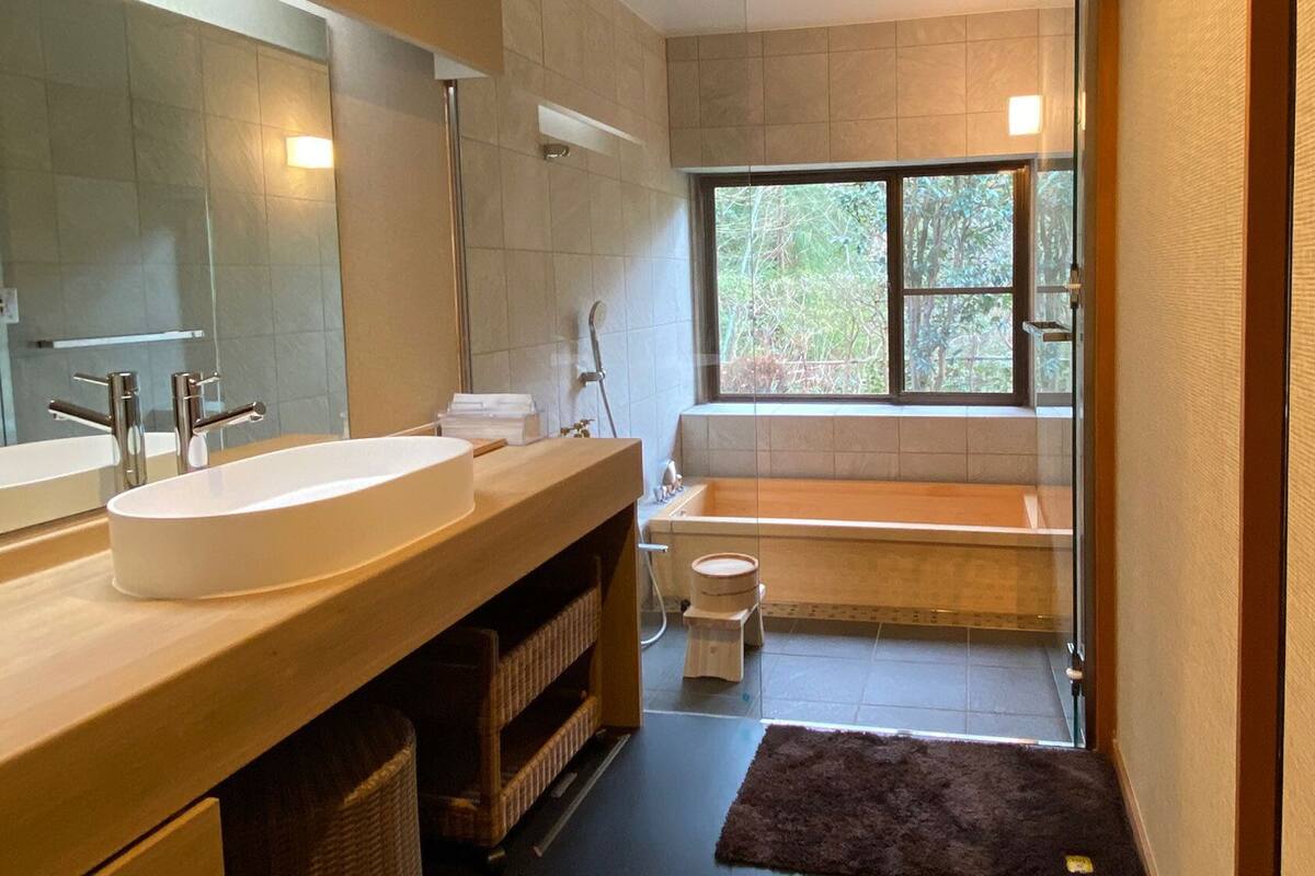 A bathroom with a large sink, mirror, and bathtub.