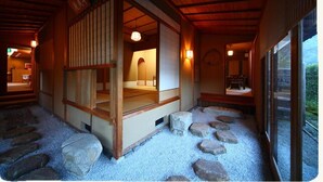 Ein traditioneller japanischer Raum mit Tatami-Böden, einer Schiebetür und einem Kiesweg zum Eingang.
