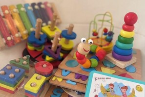 A collection of children's educational toys, including stacking rings and wooden blocks, arranged on a table. - Zenzen Pool Villa (San Sai)