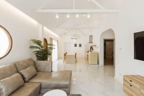 A modern living room with a leather sofa, a coffee table, and a potted plant. - Zenzen Pool Villa (San Sai)