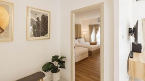 A hotel room with a bed, bedside table, lamp, and a plant. - Zenzen Pool Villa (San Sai)