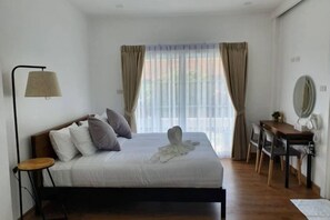 A bedroom with a bed, bedside table, lamp, and a view of the outdoors through curtains. - Zenzen Pool Villa (San Sai)