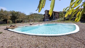 A swimming pool surrounded by pebbles, with a stone building in the background. - Chalet 'Masia La Clariana' with Mountain Views, Private Pool and Wi-Fi (Castelltallat)