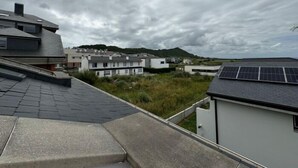 A residential area with modern houses, a sloped roof, and solar panels. - Rental unit in Liencres · ★New · 3 bedrooms · 3 beds · 2 baths (Liencres)