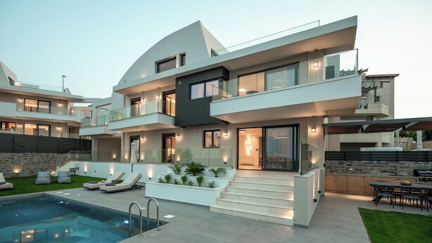 Une maison moderne à plusieurs étages, dotée d’une piscine, d’un espace extérieur aménagé et d’un patio bien éclairé.