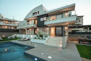 A modern multi-story house with a swimming pool, outdoor seating, and a well-lit patio area. - Anama Villa I, with Pool & Views to Rethymno (9C6Q+GX5 Violi Charaki)