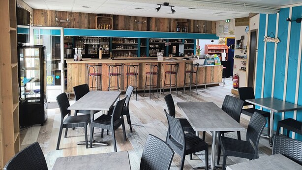A restaurant with a bar area, wooden walls, and a mix of bar stools and tables. - Hôtel Bar Restaurant La Marie Galante (Saint-Georges-d'Oleron)