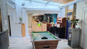 A pool table in a room with a wooden ceiling and tiled flooring. - Hôtel Bar Restaurant La Marie Galante (Saint-Georges-d'Oleron)