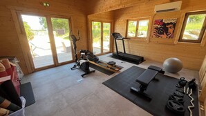 A gym with exercise equipment, including a treadmill, stationary bike, and weights.