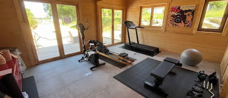 Ett gym med träningsutrustning, inklusive löpband, motionscykel och vikter.