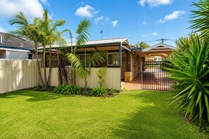 A residential property with a fenced backyard, a covered patio, and a gated entrance. - Sea Renity On Earnshaw (West Busselton)