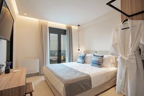 A modern hotel room with a large bed, a desk, and a TV.