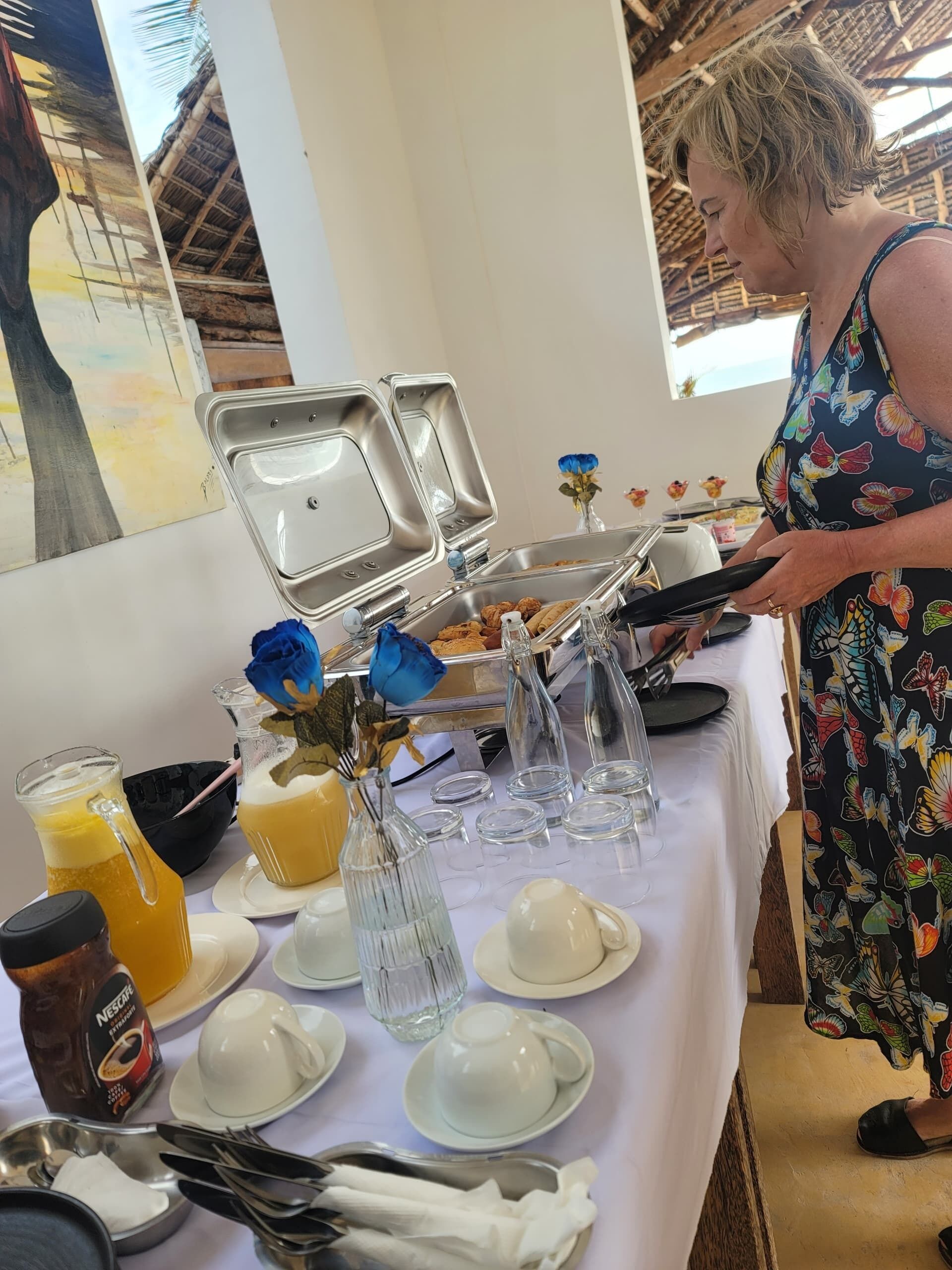 Montaje de bufé con diversos alimentos, bebidas y utensilios sobre una mesa.