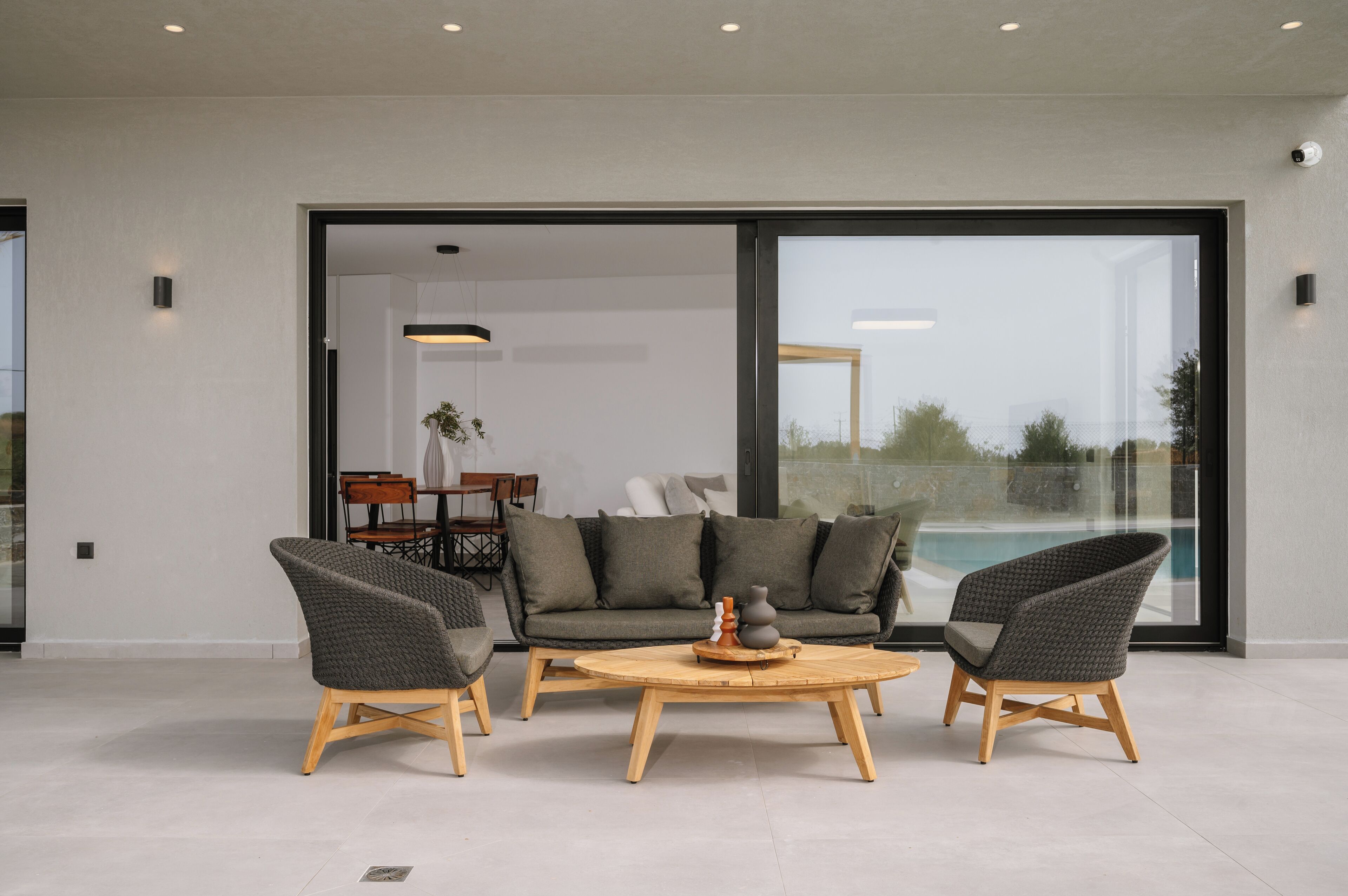 A modern living room with a sofa, two armchairs, and a coffee table.
