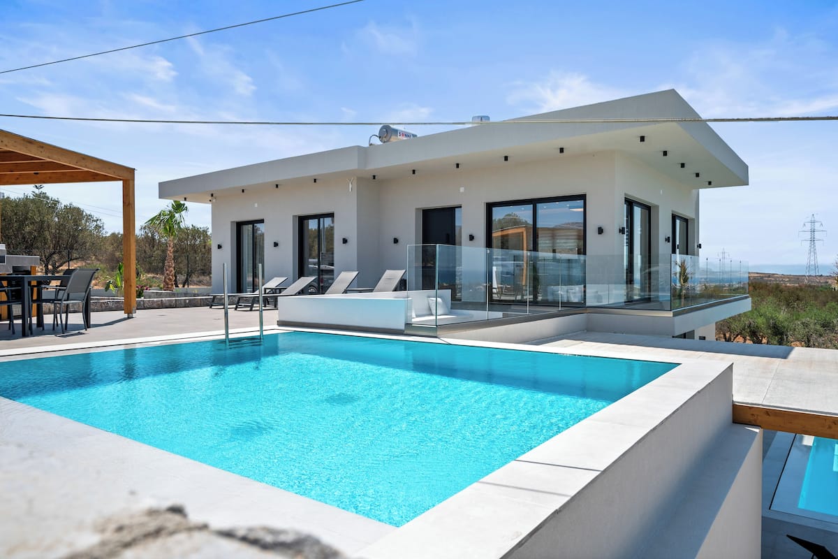 Una casa moderna con piscina, amplios ventanales y un espacio de patio.