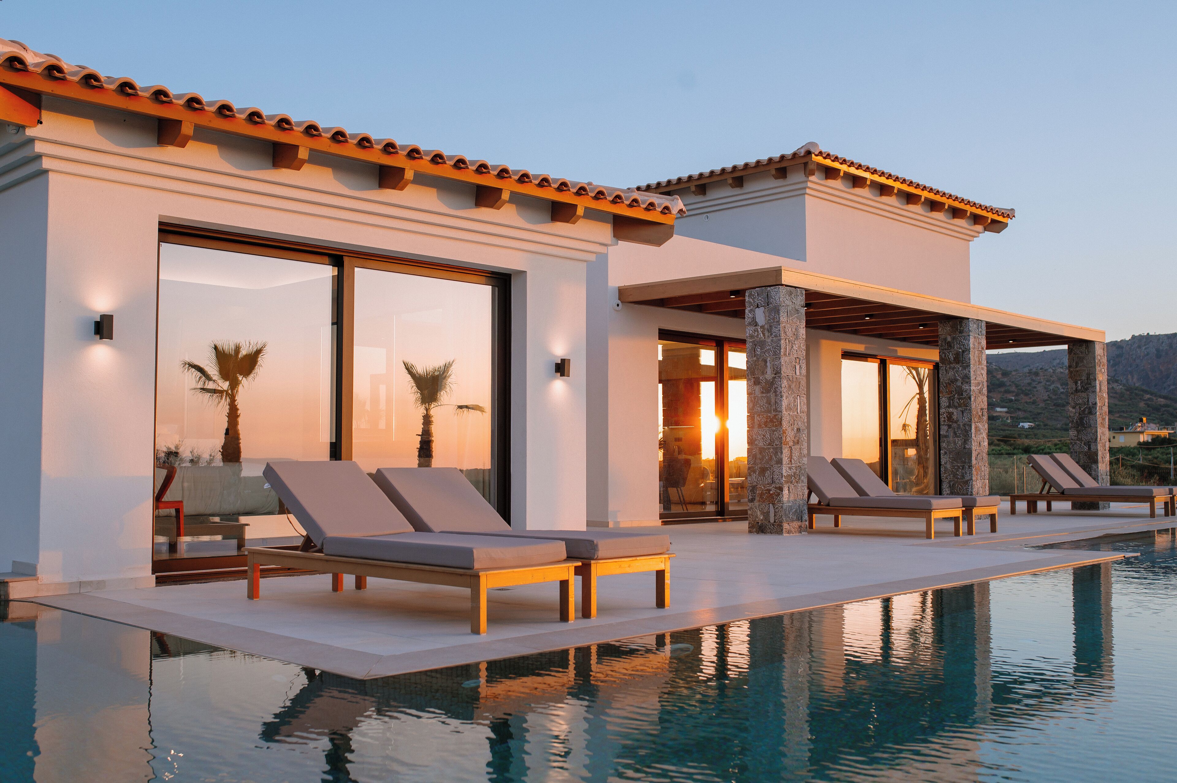 Un moderno resort con piscina, sillas de descanso y vistas a las montañas.