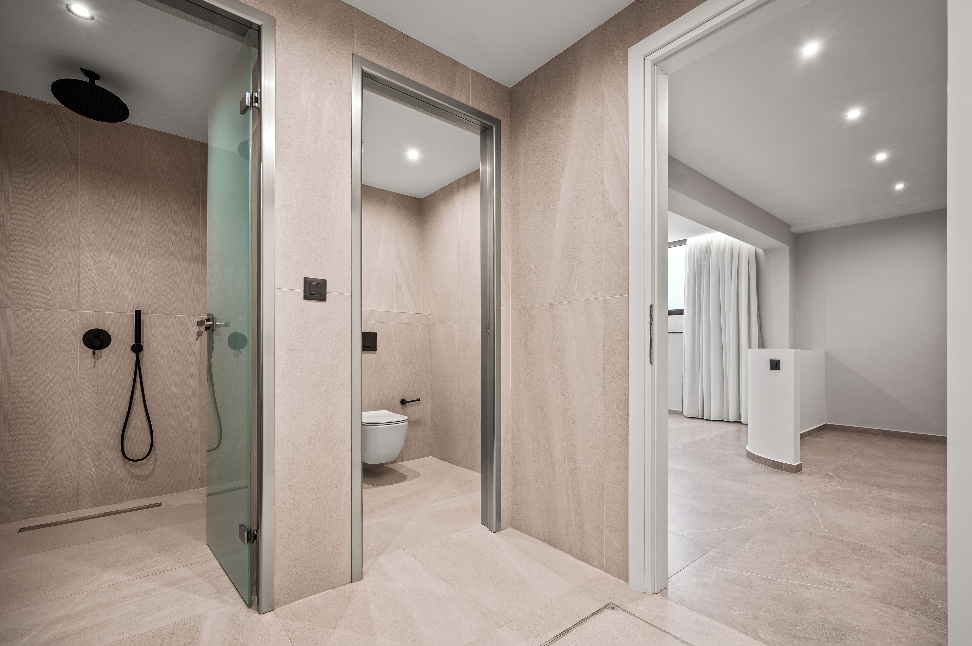 A modern bathroom with a glass shower enclosure, a toilet, and a walk-in shower.