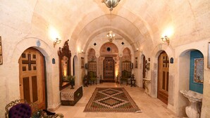 An interior with arched ceilings, a central chandelier, and a patterned rug. - 1860 KADIEVİ (Ürgüp)