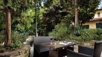 An outdoor patio with wicker furniture, a table, and a wine glass.