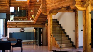 A spacious interior with a wooden staircase, a dining area, and a kitchen.
