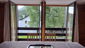 Une pièce avec une grande fenêtre, des meubles en bois et un plateau sur la table.