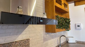 A kitchen with a stainless steel range hood, wooden cabinets, and a built-in herb garden. - Charming rural house Casa Zalo for 2-4 people in Mestas de Con (Cangas de Onís)