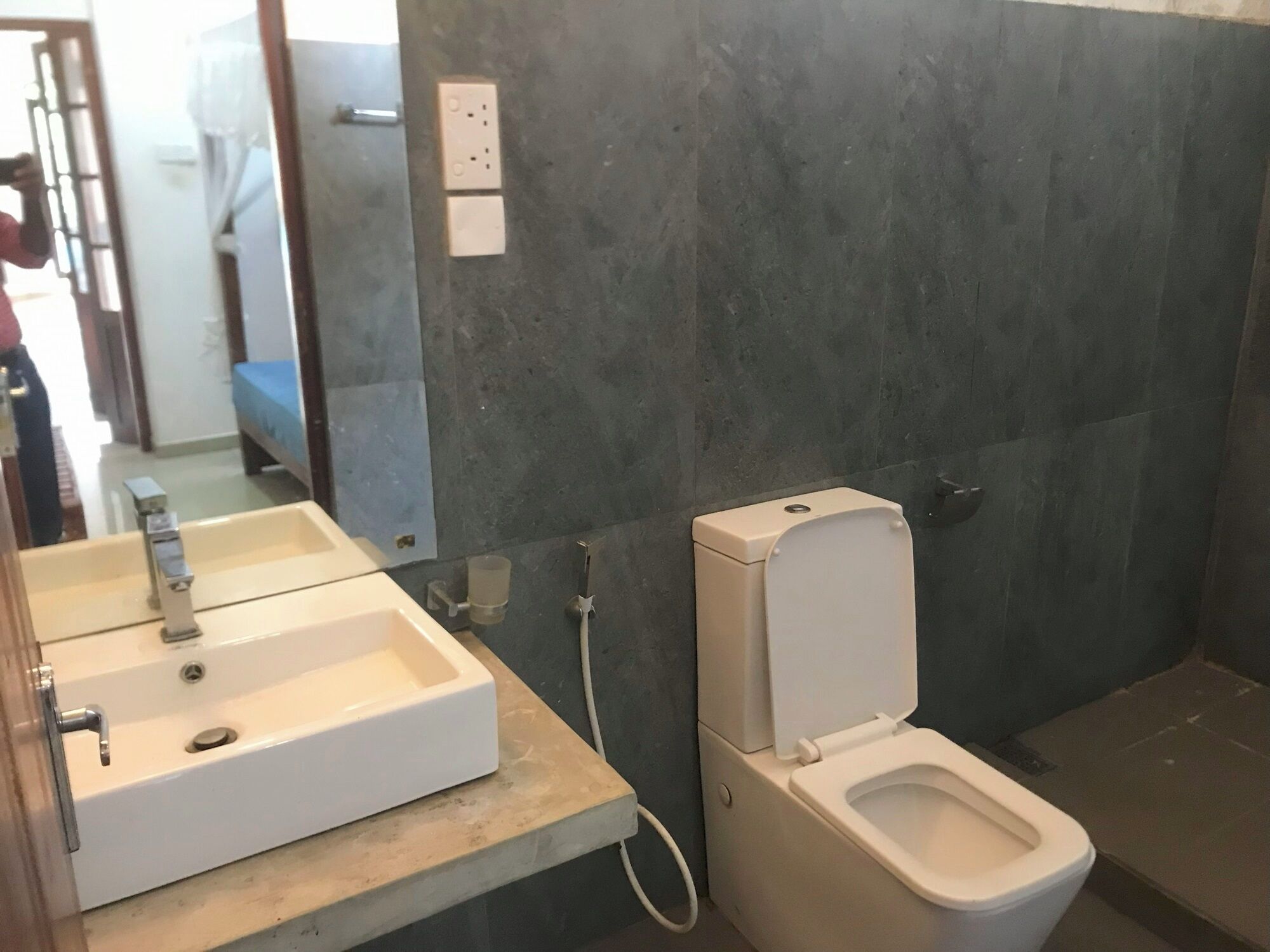 Un baño con un lavabo blanco, un inodoro y un espejo.