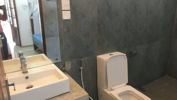 Un baño con un lavabo blanco, un inodoro y un espejo.