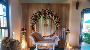 A room with a white sofa, floral decorations, and a green carpet.