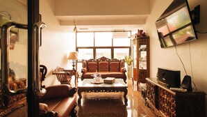 A living room with a sofa, a coffee table, a television, and a cabinet. - Reddoorz Near Lrt 2 Antipolo Station (Antipolo)