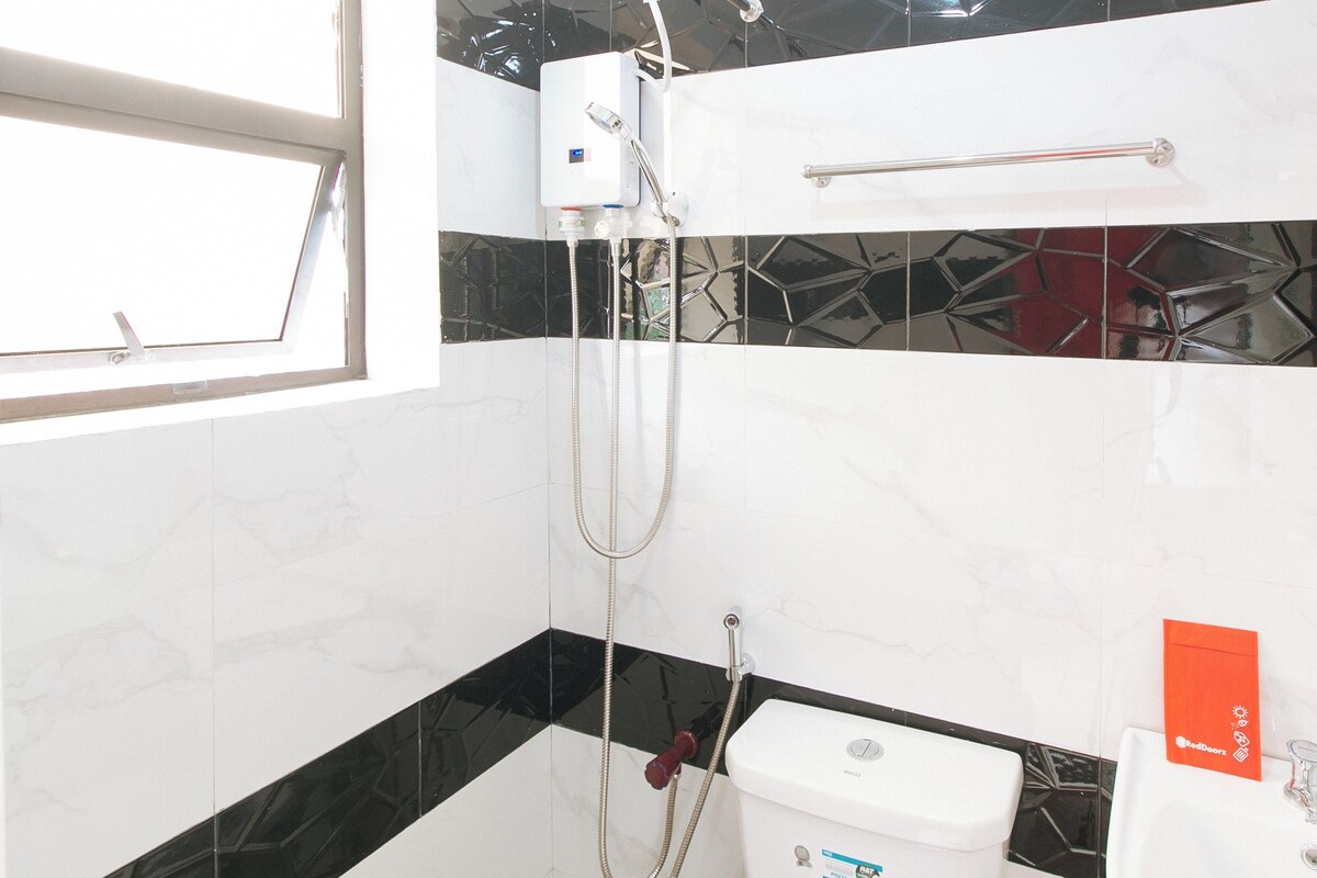 A bathroom with a toilet, bidet, and a shower with a handheld showerhead.