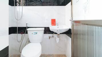Un baño con inodoro, lavabo y ducha.