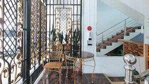 A room with a black and gold gate, a round table, and a chair. - Reddoorz Near Lrt 2 Antipolo Station (Antipolo)