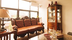 A room with a leather sofa, a glass cabinet with decorative items, and a lamp. - Reddoorz Near Lrt 2 Antipolo Station (Antipolo)