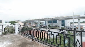 Ein Hochhaus mit moderner Architektur, gekennzeichnet durch eine markante Glasfassade und eine Dachterrasse mit Metallgeländer.