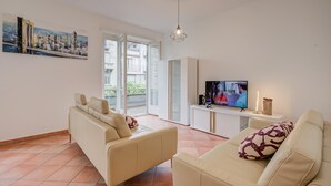 A modern living room with a sofa, TV, and artwork on the wall. - Bellinzona in Centro (Bellinzona)